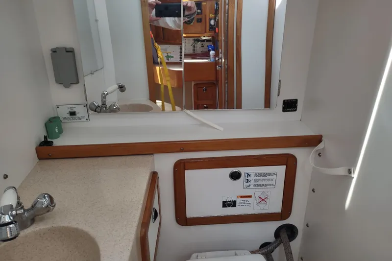 Spotted Drum II Yacht Photos Pics Bathroom interior of a 2004 Catalina 42 Mk II sailboat, featuring a sink and mirror.