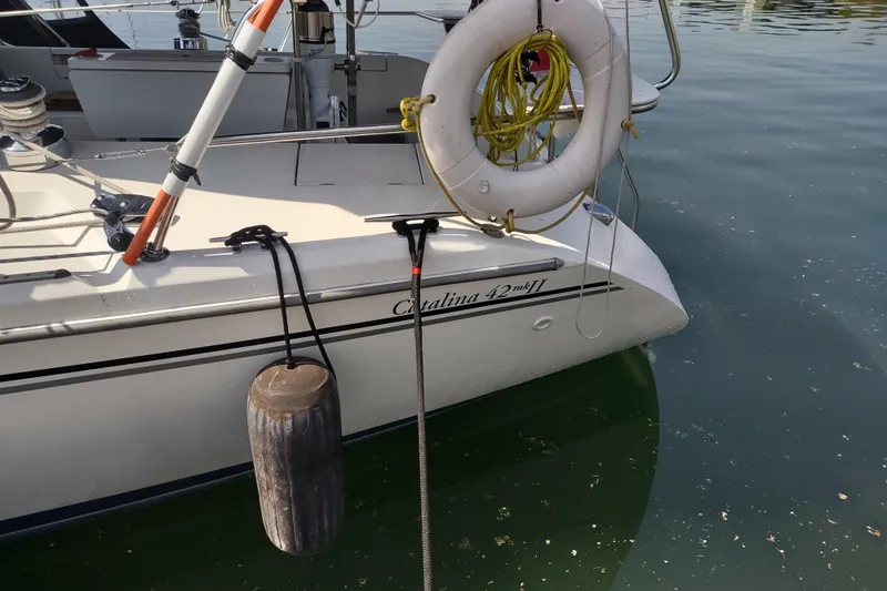 Spotted Drum II Yacht Photos Pics 2004 Catalina 42 Mk II sailboat with fender and life ring docked in calm water.