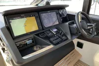 Control panel of 2016 Princess V58 Open yacht with navigation screens and steering wheel.