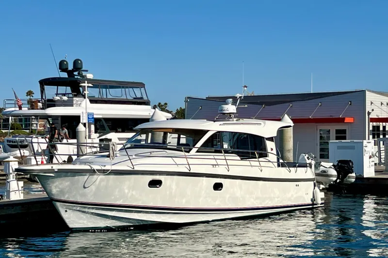 Kala Yacht Photos Pics 2018 Nimbus 365 Coupe yacht docked at marina under clear blue sky.