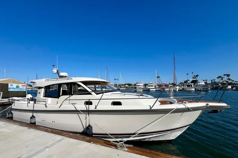 Kala Yacht Photos Pics 2018 Nimbus 365 Coupe boat docked in a marina under clear blue skies.