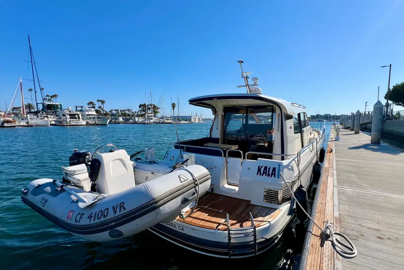 Kala Yacht Photos Pics Nimbus 365 Coupe 2018 docked with inflatable boat, sunny marina backdrop.