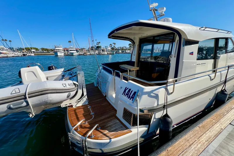 Kala Yacht Photos Pics 2018 Nimbus 365 Coupe yacht docked with inflatable boat, sunny marina setting.