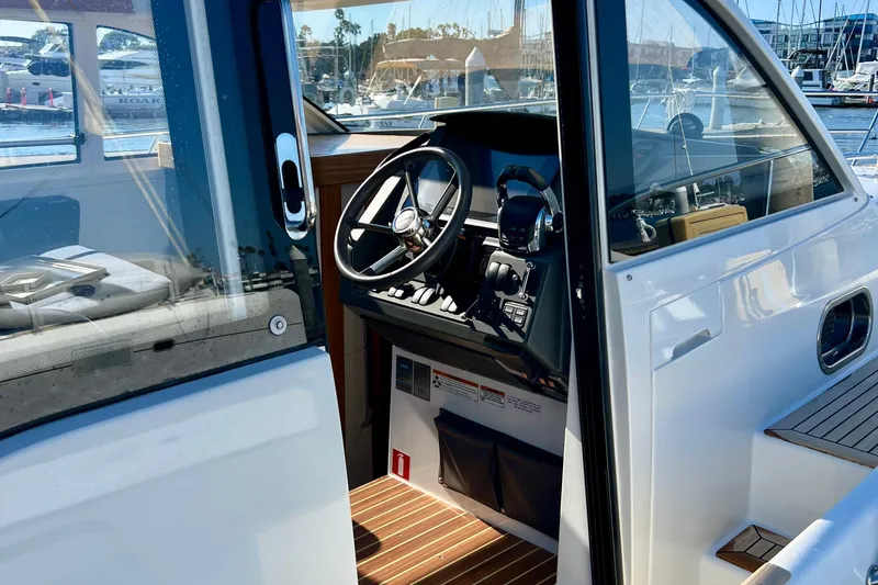 Kala Yacht Photos Pics Interior view of 2018 Nimbus 365 Coupe boat cockpit with steering wheel and controls.