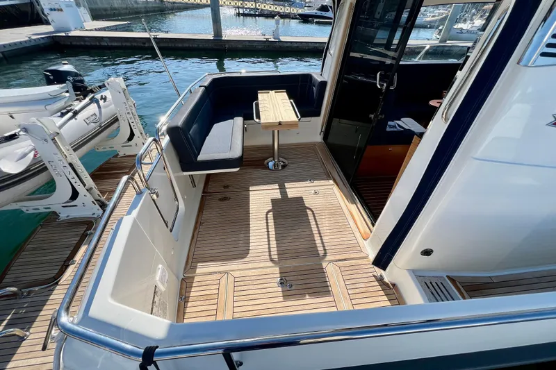 Kala Yacht Photos Pics Nimbus 365 Coupe 2018 boat deck with seating and table, docked at marina.