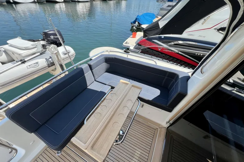 Kala Yacht Photos Pics 2018 Nimbus 365 Coupe yacht with elegant seating and wooden table, docked at marina.