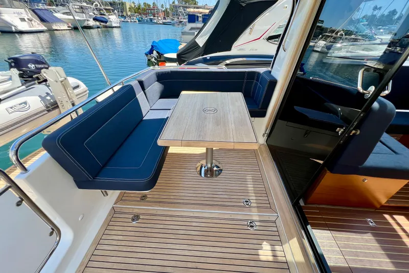 Kala Yacht Photos Pics 2018 Nimbus 365 Coupe yacht with elegant seating and wooden deck in a marina setting.