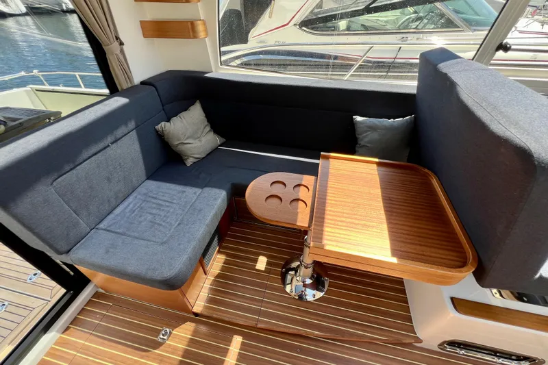 Kala Yacht Photos Pics Interior of 2018 Nimbus 365 Coupe with cozy seating and wooden table.