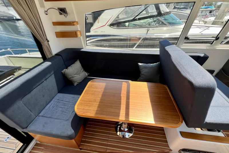 Kala Yacht Photos Pics Interior of 2018 Nimbus 365 Coupe with cozy seating and wooden table.
