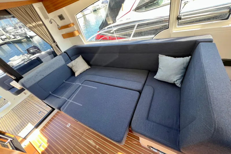 Kala Yacht Photos Pics Luxurious interior of 2018 Nimbus 365 Coupe with blue seating and wooden flooring.