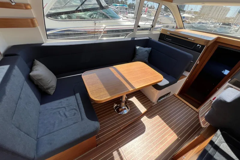 Kala Yacht Photos Pics Interior of 2018 Nimbus 365 Coupe with cozy seating and wooden table.