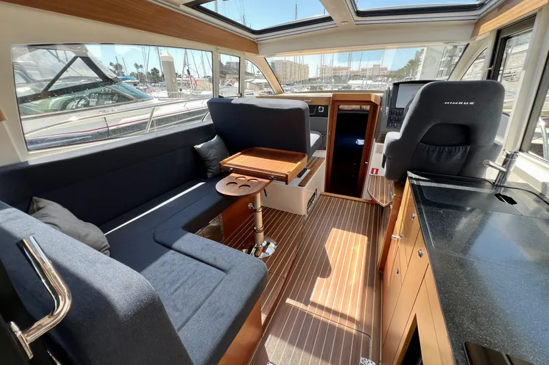 Kala Yacht Photos Pics Interior of 2018 Nimbus 365 Coupe yacht with seating, table, and helm station.