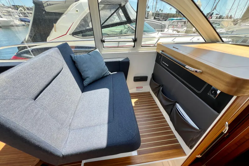 Kala Yacht Photos Pics Interior of 2018 Nimbus 365 Coupe with blue seating and wooden accents.