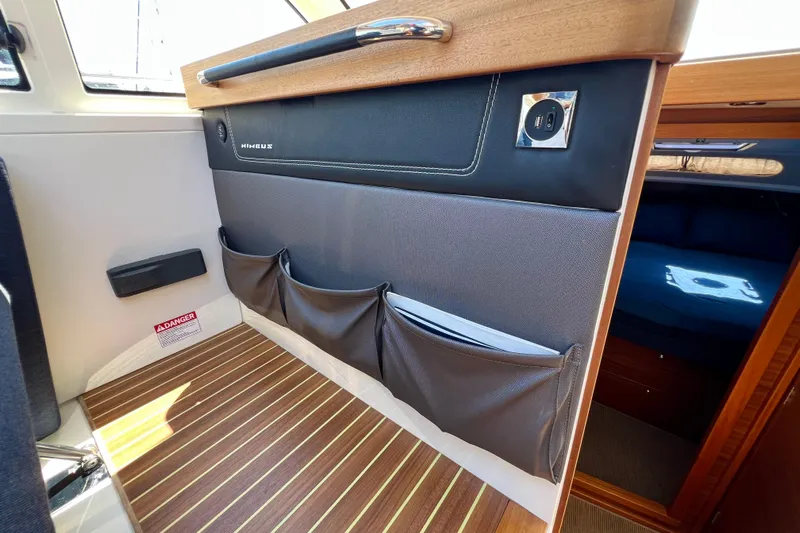 Kala Yacht Photos Pics Interior of 2018 Nimbus 365 Coupe boat with storage pockets and wood flooring.