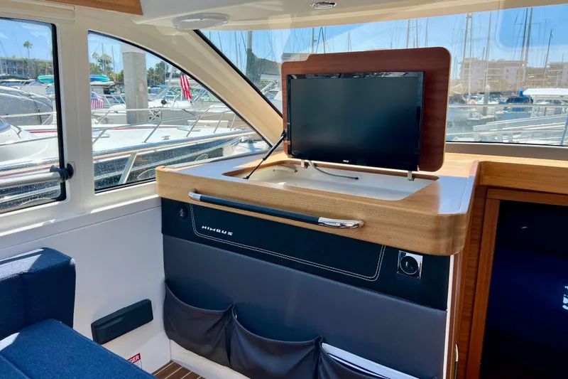 Kala Yacht Photos Pics Interior of 2018 Nimbus 365 Coupe with TV, wooden accents, and marina view.