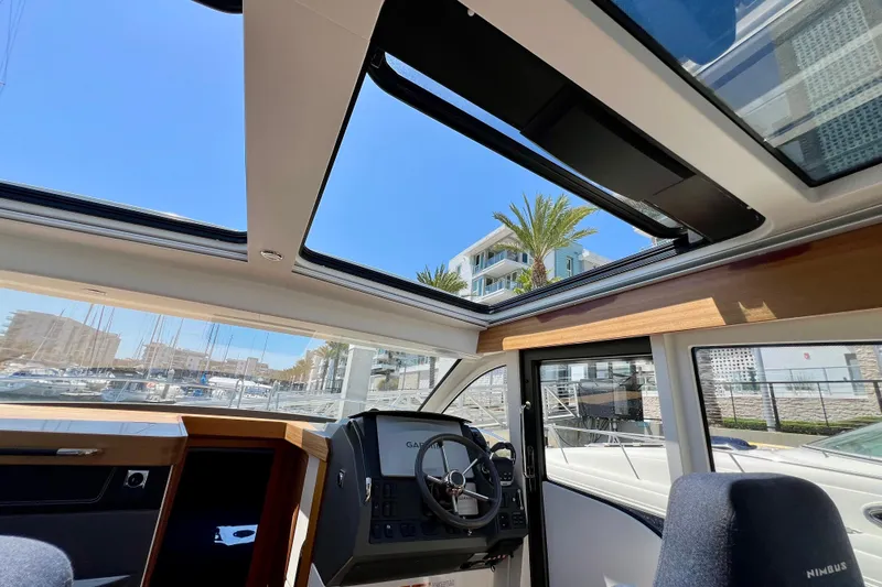 Kala Yacht Photos Pics Interior view of 2018 Nimbus 365 Coupe boat with open sunroof and marina backdrop.