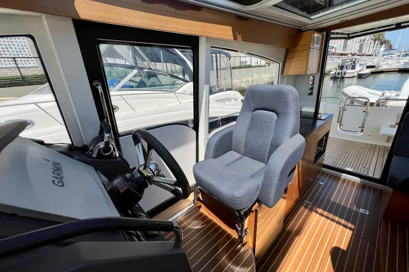 Kala Yacht Photos Pics Interior of 2018 Nimbus 365 Coupe boat with helm seat and wooden flooring.
