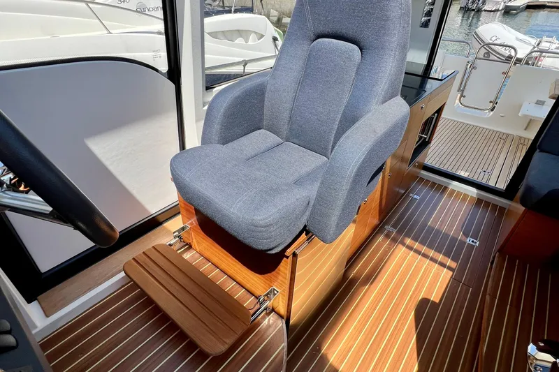 Kala Yacht Photos Pics Captain's chair in 2018 Nimbus 365 Coupe, featuring sleek design and wooden flooring.