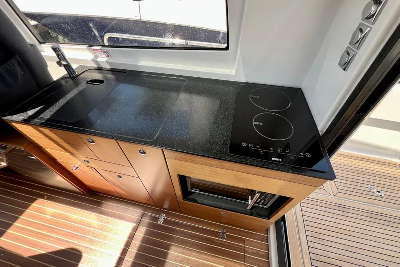 Kala Yacht Photos Pics Modern kitchen area in 2018 Nimbus 365 Coupe with sleek black countertop and stove.
