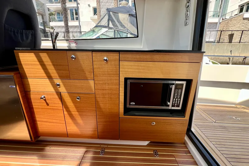 Kala Yacht Photos Pics Wooden interior of 2018 Nimbus 365 Coupe with microwave and cabinets.