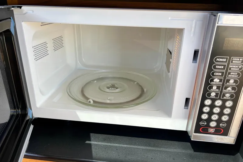 Kala Yacht Photos Pics Open microwave oven with control panel and glass turntable inside.