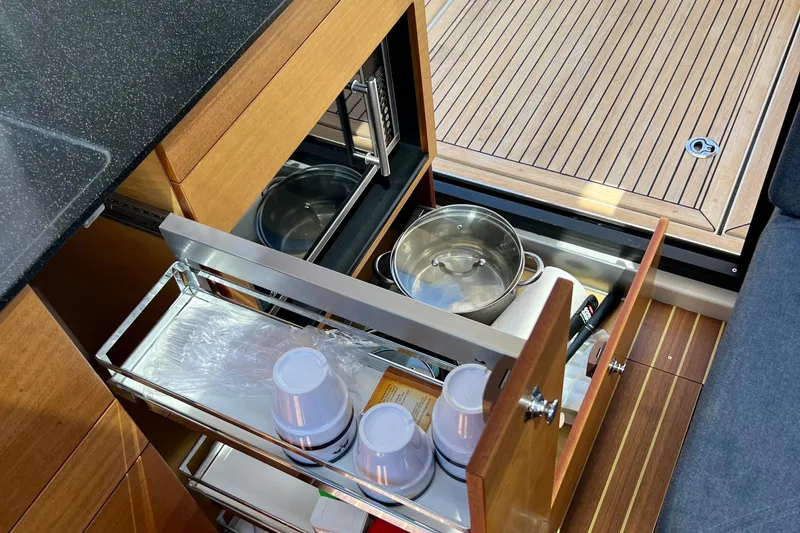 Kala Yacht Photos Pics Kitchen storage in 2018 Nimbus 365 Coupe with pots and cups, wooden flooring.
