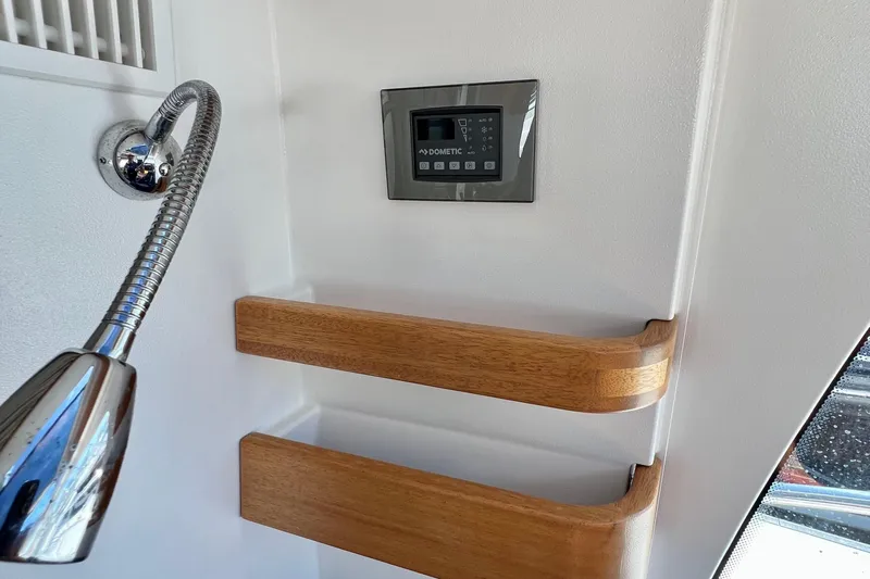 Kala Yacht Photos Pics Interior of 2018 Nimbus 365 Coupe with control panel and wooden shelves.