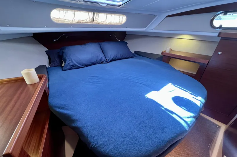Kala Yacht Photos Pics Cozy cabin interior of 2018 Nimbus 365 Coupe with blue bedding and wooden accents.