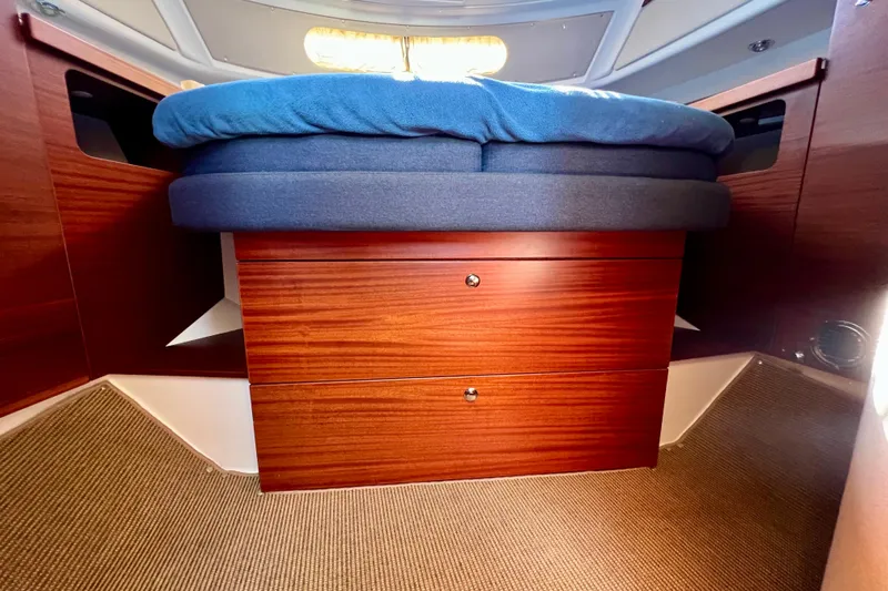 Kala Yacht Photos Pics Interior of 2018 Nimbus 365 Coupe with wooden drawers and blue cushioned bed.