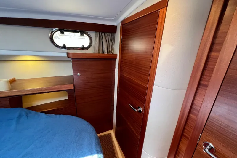 Kala Yacht Photos Pics Interior cabin of 2018 Nimbus 365 Coupe with wooden finish and porthole window.