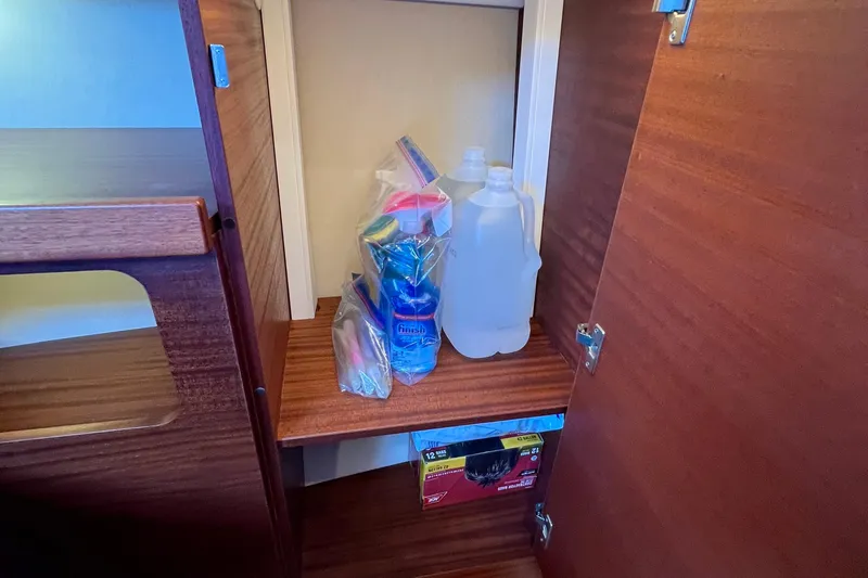 Kala Yacht Photos Pics Storage cabinet in 2018 Nimbus 365 Coupe with cleaning supplies and water bottles.