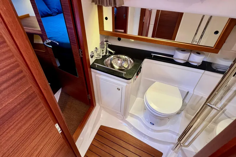 Kala Yacht Photos Pics Luxurious bathroom in 2018 Nimbus 365 Coupe yacht with modern fixtures and wooden accents.