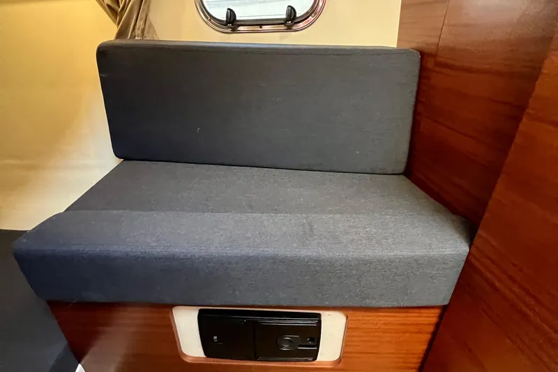 Kala Yacht Photos Pics Interior seating of 2018 Nimbus 365 Coupe with gray cushions and wooden paneling.