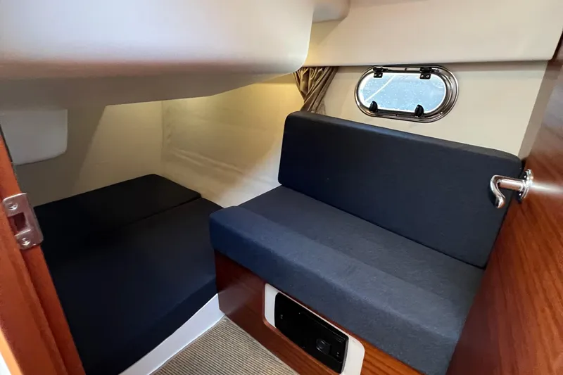 Kala Yacht Photos Pics Interior cabin of 2018 Nimbus 365 Coupe with seating and porthole window.