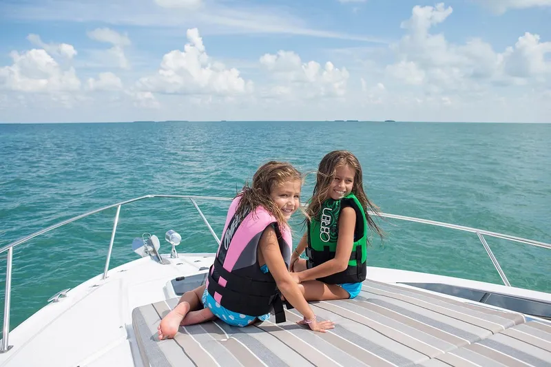 Popsicle Yacht Photos Pics Two children on a 2019 Regal 35 Sport Coupe boat, enjoying the ocean.