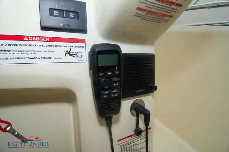  Yacht Photos Pics 2024 Invictus TT280S boat dashboard with Garmin radio and safety warning labels.