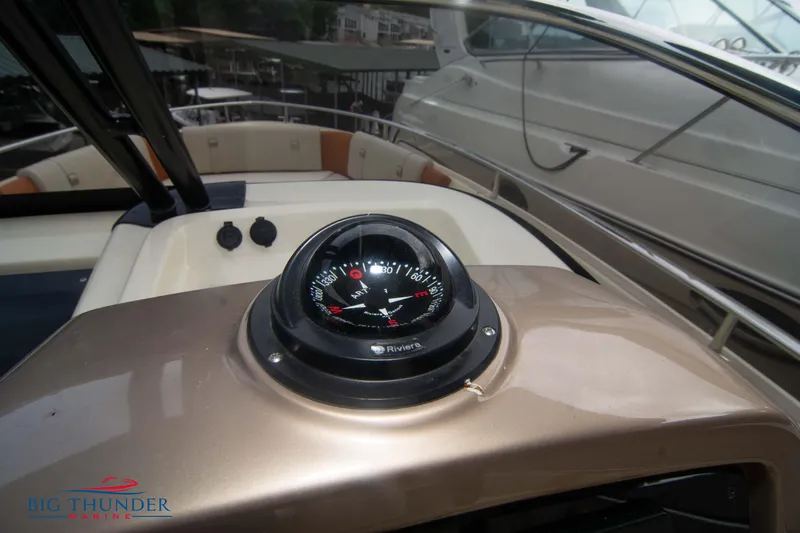  Yacht Photos Pics 2024 Invictus TT280S boat dashboard with compass, featuring sleek design and modern controls.