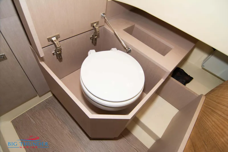  Yacht Photos Pics 2024 Invictus TT280S boat bathroom with modern toilet and wooden cabinetry.