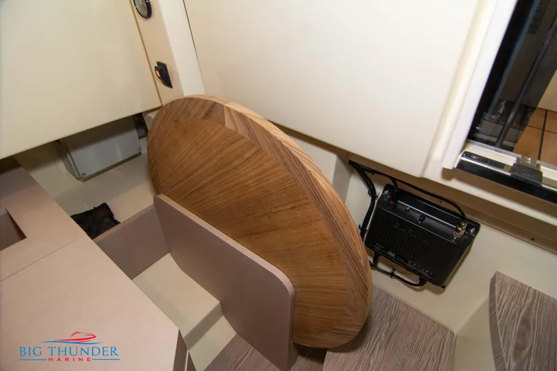  Yacht Photos Pics 2024 Invictus TT280S interior with wooden table and marine equipment.