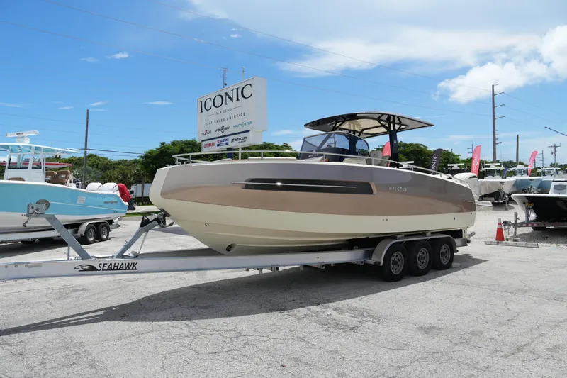  Yacht Photos Pics 2024 Invictus TT280S boat on trailer at Iconic Marine dealership under clear sky.