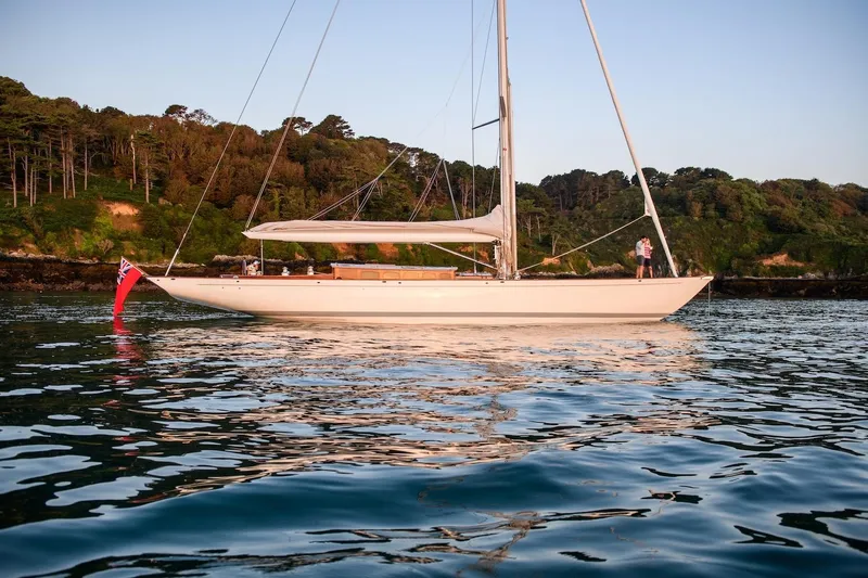 Gwenhyfar II Yacht Photos Pics 2023 Spirit Yachts C72 sailing on calm waters near a forested shoreline.