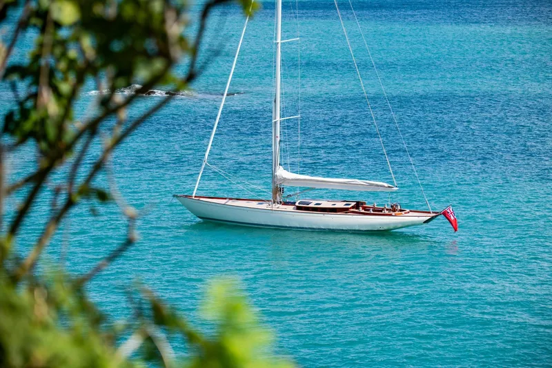 Gwenhyfar II Yacht Photos Pics Sleek 2023 Spirit Yachts C72 sailboat on turquoise waters, framed by lush greenery.