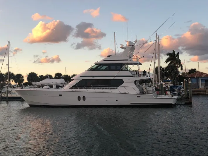 Reel Life Yacht Photos Pics 1996 Hatteras 82 Convertible yacht docked at sunset with palm trees.