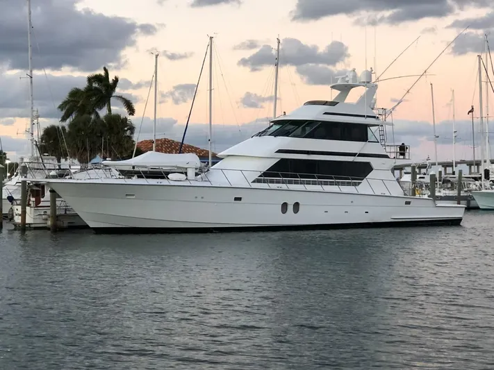 Reel Life Yacht Photos Pics 1996 Hatteras 82 Convertible yacht docked at marina during sunset.