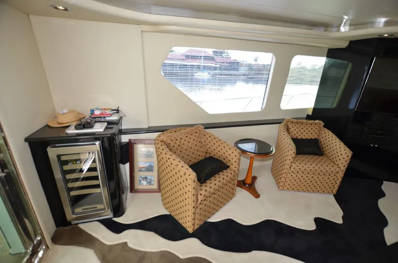 Reel Life Yacht Photos Pics Luxurious interior of 1996 Hatteras 82 Convertible yacht with seating and wine cooler.