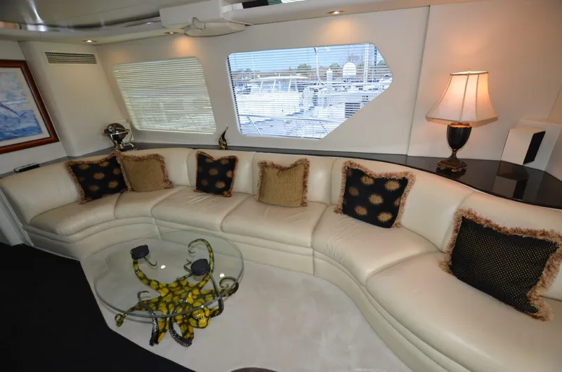 Reel Life Yacht Photos Pics Luxurious interior of 1996 Hatteras 82 Convertible yacht with elegant seating and decor.