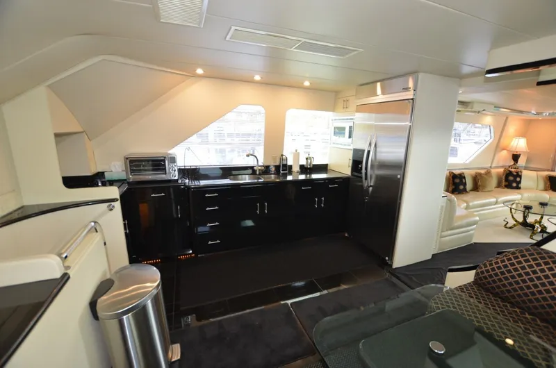 Reel Life Yacht Photos Pics Luxurious interior of 1996 Hatteras 82 Convertible yacht with modern kitchen amenities.