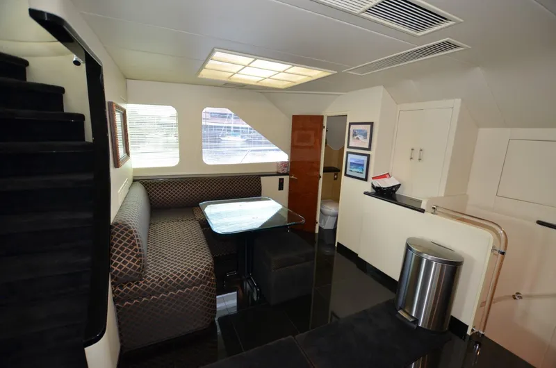 Reel Life Yacht Photos Pics Interior of 1996 Hatteras 82 Convertible yacht with dining area and modern decor.