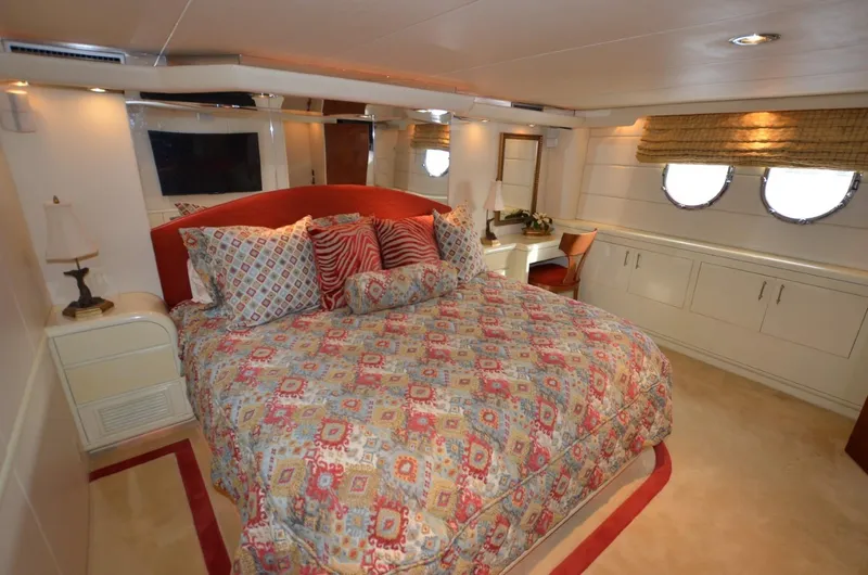 Reel Life Yacht Photos Pics Luxurious bedroom on 1996 Hatteras 82 Convertible yacht with colorful bedding and elegant decor.