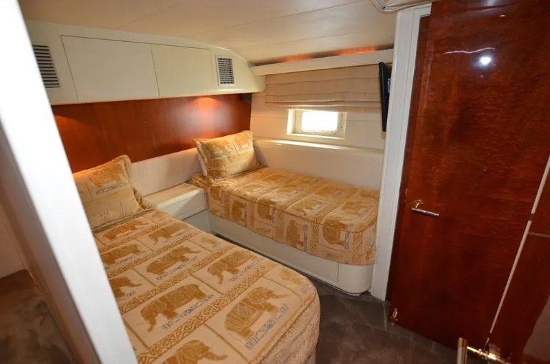 Reel Life Yacht Photos Pics Cozy twin bedroom in 1996 Hatteras 82 Convertible yacht with elegant wood finishes.
